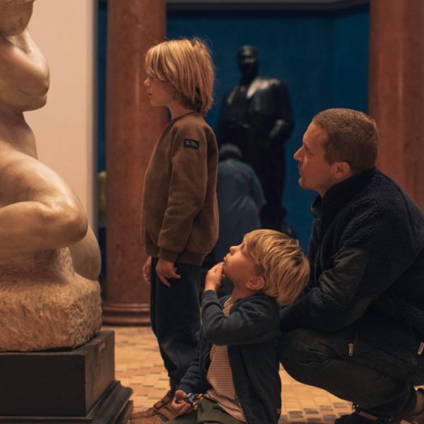 To børn med deres far betragter skulptur på besøg på Faaborg Museum