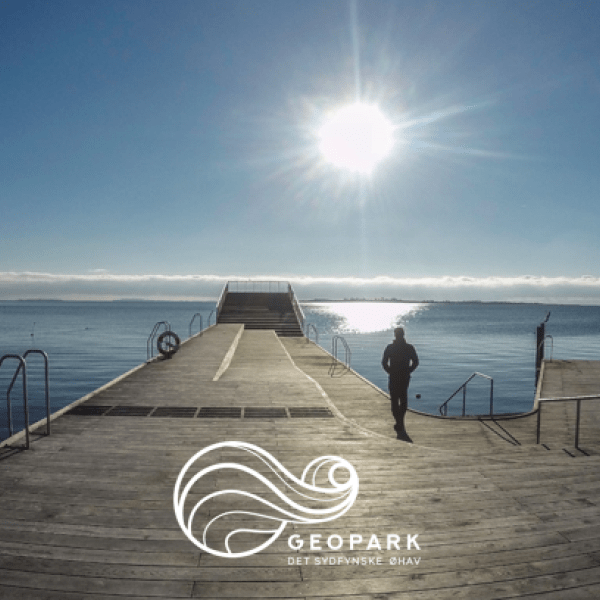 Geopark Det Sydfynske Øhav logo påført Faaborg Havnebad i solopgang