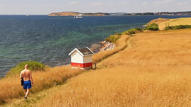 Bjørnø sommeren 2022 | Gæst der vandrer ved Bjørnø Fyr | VisitFaaborg