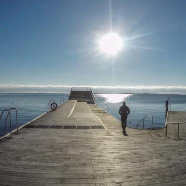 Faaborg Havnebad i solopgang med kvinde | Ferie i en Geopark | Det Sydfynske Øhav | VisitFaaborg