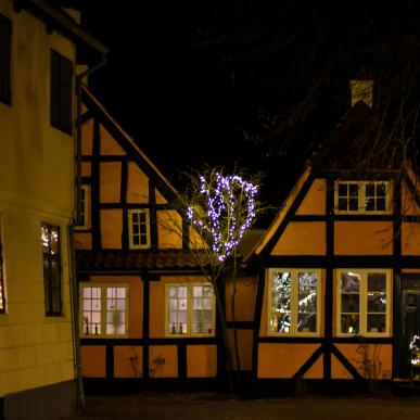 Julelys glimter ved orange bygning i Faaborg