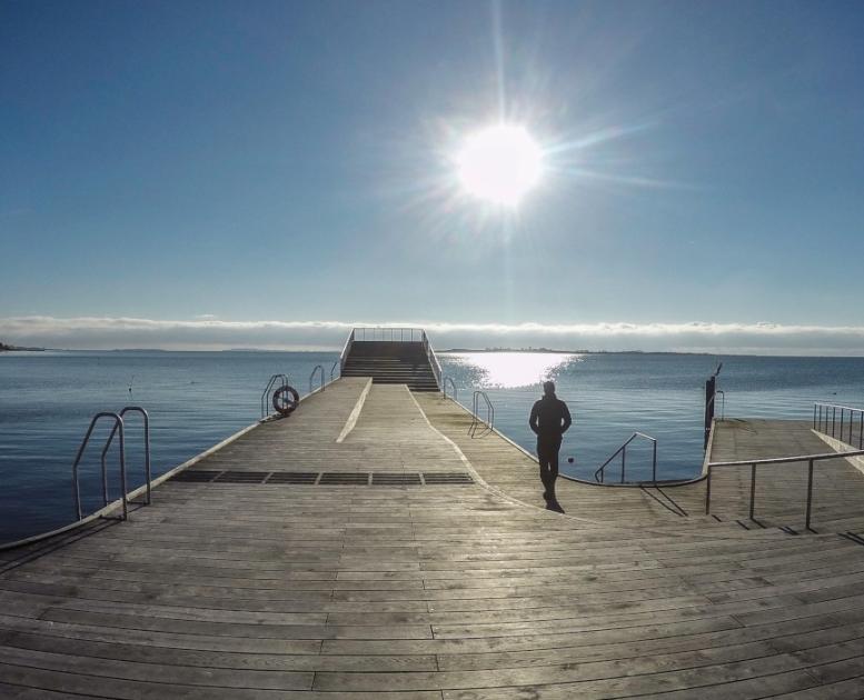 Faaborg Havnebad i solopgang med kvinde | Ferie i en Geopark | Det Sydfynske Øhav | VisitFaaborg